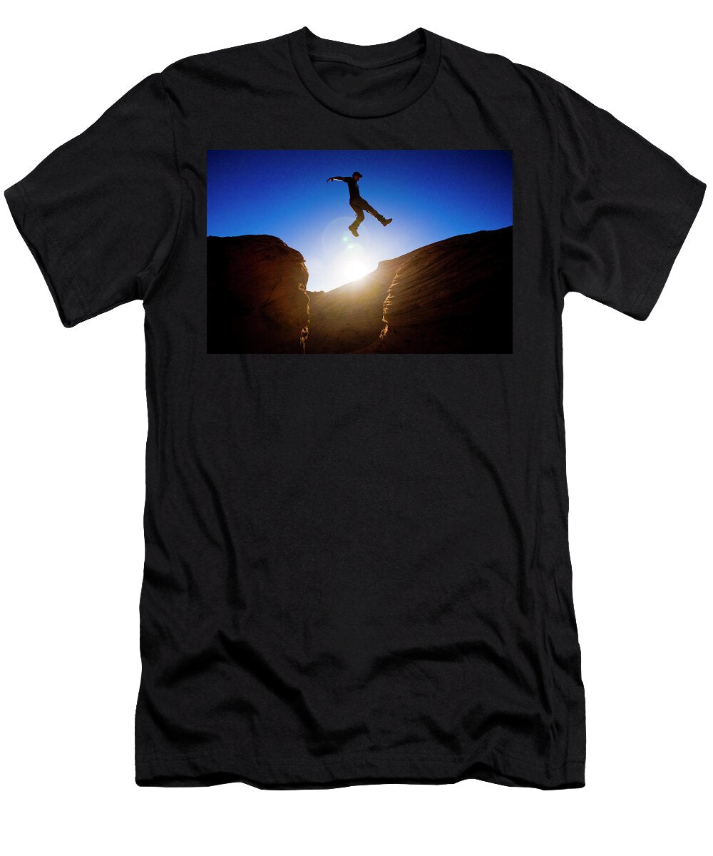1 a Man Jumps Across a Chasm While Hiking Kirk Mastin T-Shirt